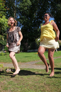 Full length of smiling young woman in park