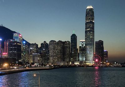 Illuminated buildings in city against sky at night