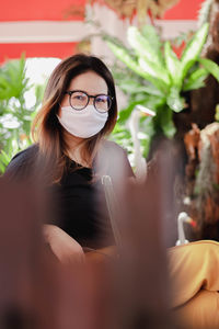 Portrait of woman wearing eyeglasses sitting outdoors