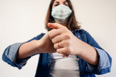 Midsection of couple holding hands against white background