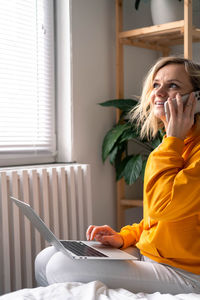 Young woman using mobile phone at home