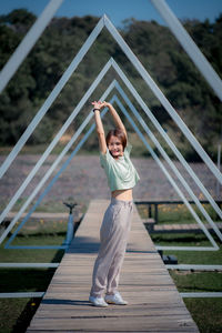 Portrait of girl standing on footbridge