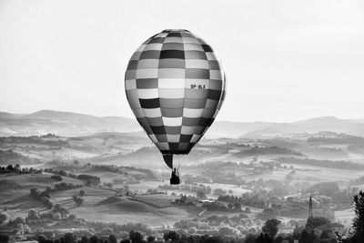 Hot air balloon flying over mountain against sky