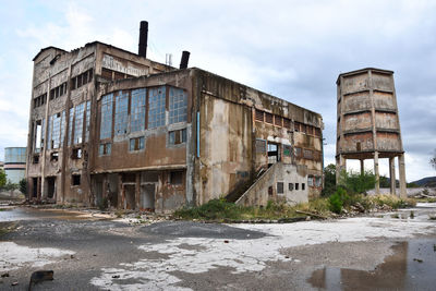 Abandoned building against sky in city