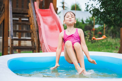 Full length of happy girl in swimming pool