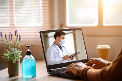 Man using mobile phone while sitting on table