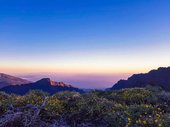 Scenic view of mountains against clear sky during sunset