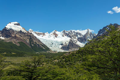 Scenic view of snowcapped mountains against clear blue sky