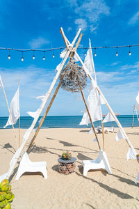 Traditional windmill on beach against sky