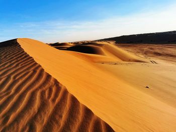 Sand dune in desert against sky