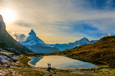 Calm lake against mountain range