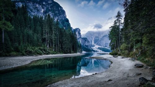 Scenic view of lake amidst mountains against cloudy sky