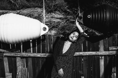 Portrait of woman standing by railing