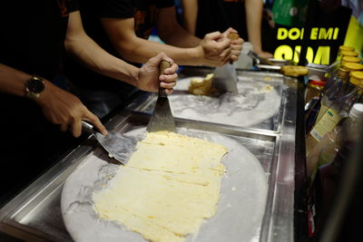 Midsection of people making ice cream