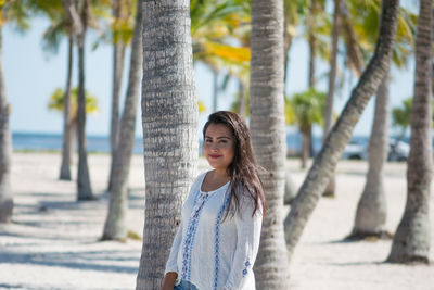 Young woman standing on tree trunk