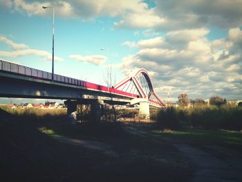 Low angle view of bridge against cloudy sky