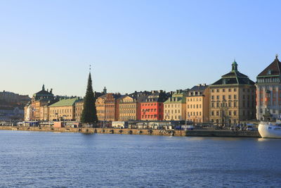 Buildings in city against clear blue sky