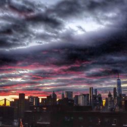 Cityscape against cloudy sky at dusk