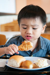 Close-up of boy eating food on table