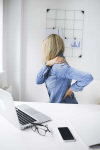 Frustrated businesswoman having backache while working from home