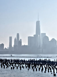 One world trade center by hudson river against sky in city