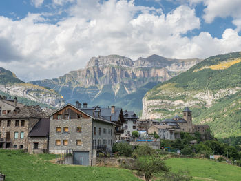 Houses by buildings against sky