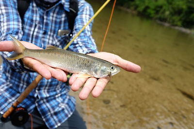 Close-up of fisherman holding fish