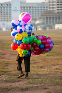 A man selling gas ballons of various colors