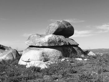 Rock formation on field against sky