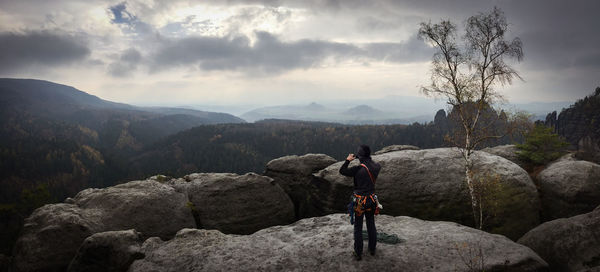 Rear view of man looking at mountain against sky