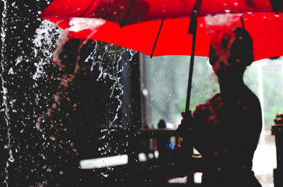 Man with umbrella standing in rain