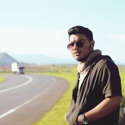 Portrait of young man standing on road