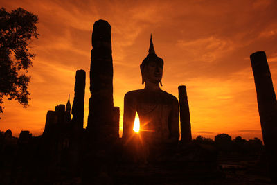 Silhouette statue against sky during sunset