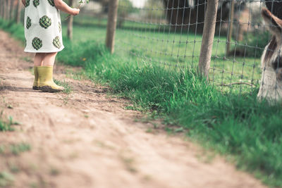 Low section of woman walking on field