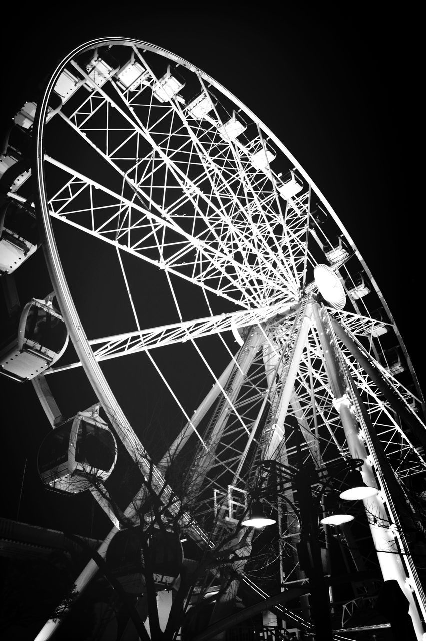 ferris wheel, low angle view, amusement park ride, amusement park, arts culture and entertainment, built structure, architecture, night, clear sky, illuminated, sky, metal, building exterior, city, tall - high, no people, outdoors, circle, travel destinations, capital cities