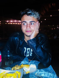 Teenager boy looking away while sitting at cafe