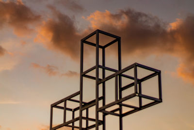 Low angle view of metallic structure against sky during sunset