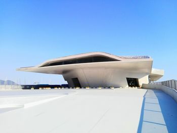 Airplane on airport runway against blue sky