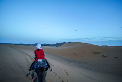 Rear view of man walking on desert