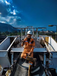 Man working at construction site against blue sky