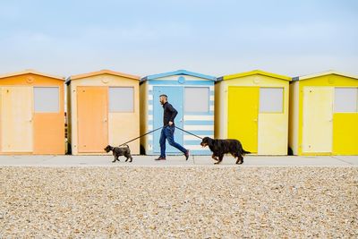 Man and yellow umbrella against sky