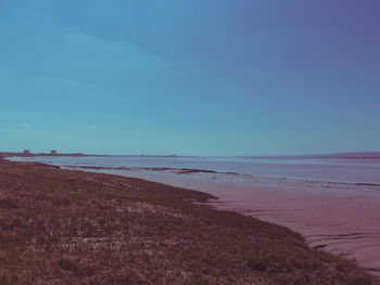 Scenic view of beach against blue sky