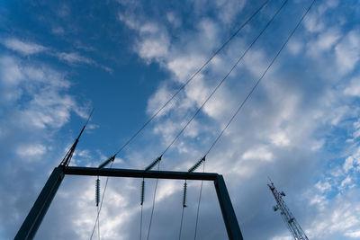 Low angle view of cranes at construction site against sky