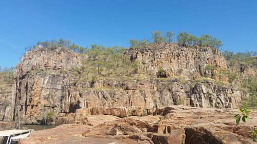 Rock formations on landscape against blue sky