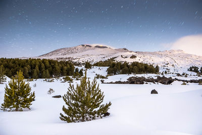 Scenic view of snowcapped mountains against sky at night