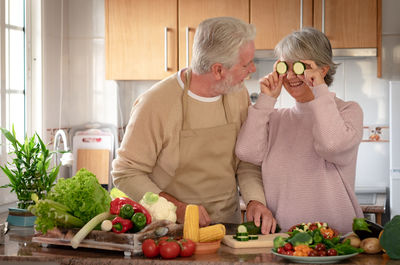 Senior couple preparing food at kitchen