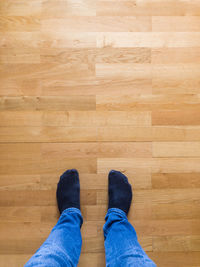 Low section of man standing on hardwood floor