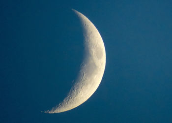 Low angle view of half moon against clear blue sky