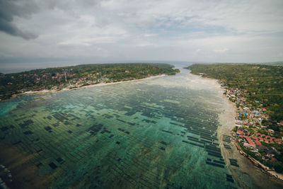 High angle view of city by sea against sky