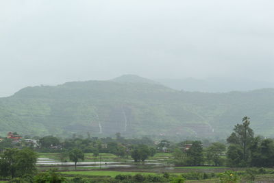 Scenic view of field and mountains against sky